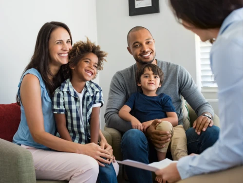 Family smiling and talking to advocate in office