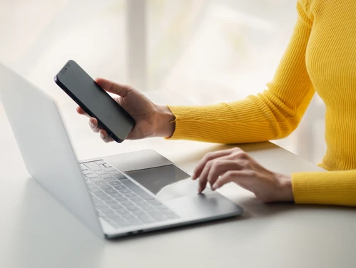 Woman working on laptop makes a call