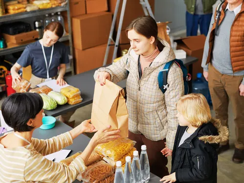 Mother and child get food from worker at shelter
