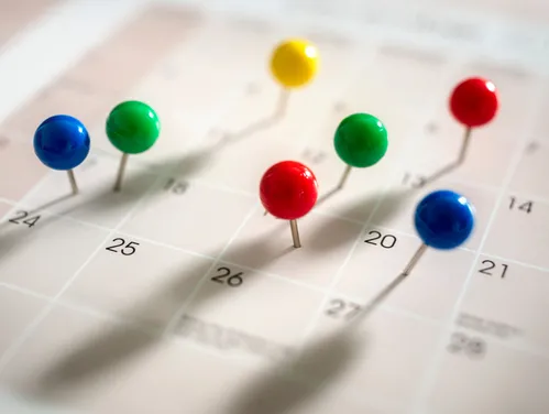 Push pins inserted to dates on calendar